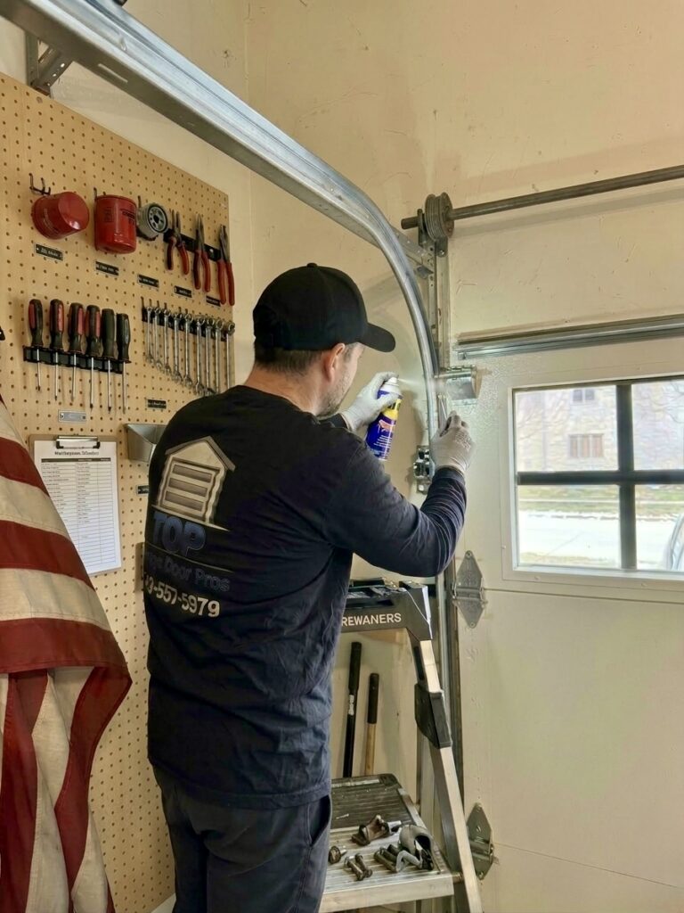 Technician performing garage door maintenance and safety inspection