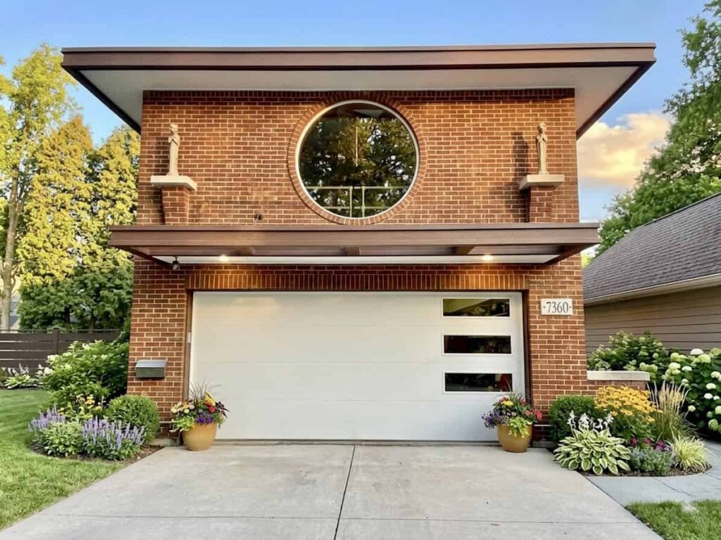 Modern white garage door installed on brick home