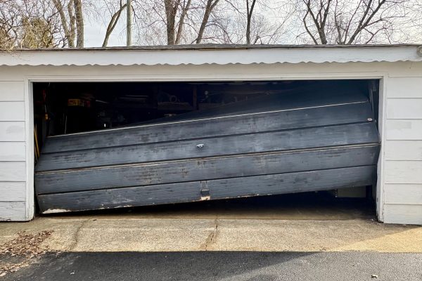 Black residential garage door needing professional repair service